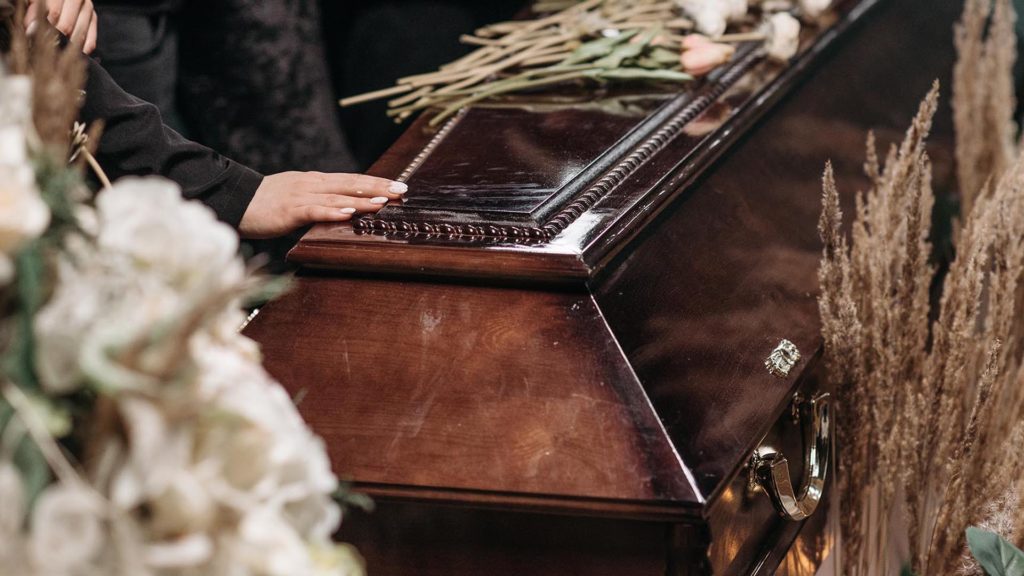 hand resting on a casket